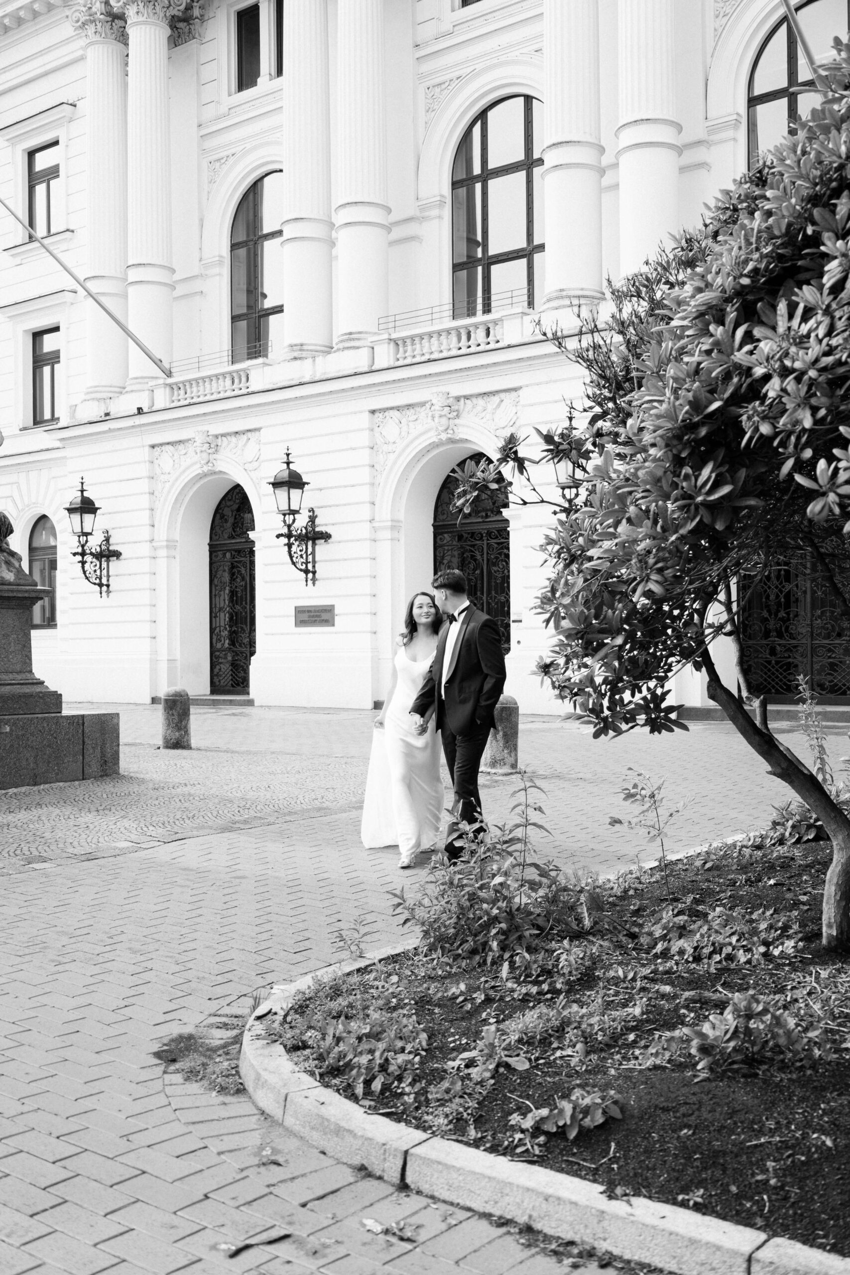 Das Brautpaar geht Hand in Hand über den Platz des Rathaus Altona nach ihrer standesamtlichen Hochzeit