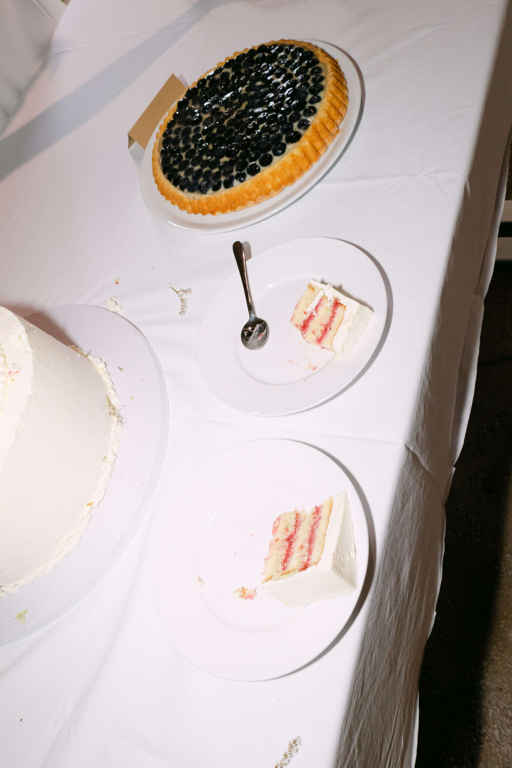 Die Hochzeitstorte wurde angeschnitten und auf zwei Teller verteilt, das Bild wurde mit Blitz von der Hochzeitsfotografin Laura Kaiser aus Hamburg aufgenommen